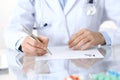 Doctor writing prescription form while sitting at glass desk in hospital, closeup view. Healthcare, insurance an Royalty Free Stock Photo