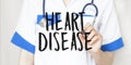 Doctor writing word HEART DISEASE with marker, Medical concept Royalty Free Stock Photo