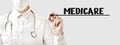 Doctor writing word MEDICARE with marker, Medical concept Royalty Free Stock Photo