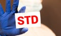 Doctor& x27;s hands in blue gloves shows the word STD sexually transmitted disease. Medical concept Royalty Free Stock Photo