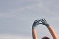 Doctor& x27;s hands in blue medical surgical gloves up to the clean sky. Woman hands in blue latex gloves.