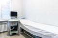 Doctor's office with couch and diagnosis tools. Close-up of ultrasound machine in clinic. Modern hospital with high Royalty Free Stock Photo