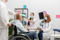 A doctor gives a patient& x27;s test results to a nurse practitioner. A 50-year-old woman in a wheelchair at the doctor& x27;s Royalty Free Stock Photo