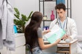 A young patient takes lab results out of her folder. Primary care physician. Doctor's office