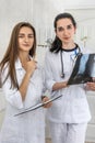 Doctor with young intern analyzing patient`s x-ray in hospital. One woman holding and and they both looking on it Royalty Free Stock Photo