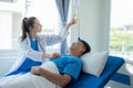 Doctor and young male patient lying in bed while checking pulse Consult Royalty Free Stock Photo