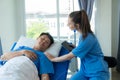 Doctor and young male patient lying in bed while checking pulse Consult Royalty Free Stock Photo