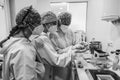 Doctors examining a dental mold. Three female doctors. Black and white. Dental health concept. Noise