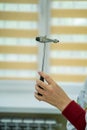 Doctors hand holding reflex hammer toward camera Royalty Free Stock Photo