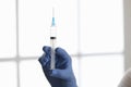 Doctors hand in rubber glove holding syringe with medicine in clinic closeup