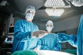 Doctors, hands and scalpel in operating room at hospital in scrubs, ppe or emergency surgery for health. Surgeon, group Royalty Free Stock Photo