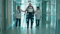 Doctors are helping a disabled man to walk in the exosuit