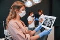 Doctors are indoors. Woman holding and looking at x-ray. In the stomatological cabinet Royalty Free Stock Photo