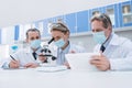Scientists working with microscope and tablet Royalty Free Stock Photo