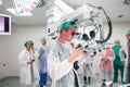 Doctors looking into the microscope in surgery room