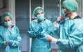 Doctors and nurse preparing to work in hospital for surgical operation during coronavirus pandemic outbreak - Medical workers