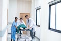 Doctors, Nurses, and Paramedics pushing stretcher gurney bed with seriously injured patient towards the operating room.