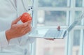 Doctors or nutritionists hold apples and laptops In the clinic To explain the benefits of fruits and vegetables. Good health Royalty Free Stock Photo