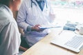 Doctors and patients sit and talk. At the table near the window