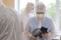 Doctors in protective suits with a medical tonometer during the coronavirus epidemic