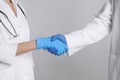 Doctors shaking hands on light grey background, closeup Royalty Free Stock Photo