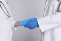 Doctors shaking hands on light grey background, closeup Royalty Free Stock Photo