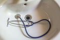Doctors stethoscope resting on a white bathroom sink Royalty Free Stock Photo