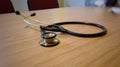 Doctors stethoscope on wooden office desk Royalty Free Stock Photo