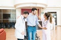 Doctors Supporting Man To Stand While Saying Goodbye At Hospital