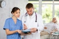 Doctor showing something in his folder to his colleague. Royalty Free Stock Photo