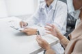 Doctors talk to patients about diagnosing problems symptoms of the disease. The doctor is taking notes on paper