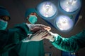 Doctors and team performing coordinate hands in bright Modern operating room with lighting equipment at hospital. Concept Teamwork Royalty Free Stock Photo