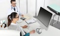 Doctors working at desk in medical office with computer Royalty Free Stock Photo