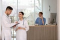 Doctors working near receptionist while she talking in hospital Royalty Free Stock Photo