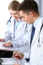 Doctors writing papers using clipboard. Physicians discussing medication program or studying at medical conference Royalty Free Stock Photo