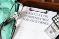 Document for calculating negligence compensation, with a stethoscope, money, and calculator on a medical uniform Royalty Free Stock Photo