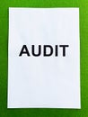 Document with title audit on green background, top view. Royalty Free Stock Photo