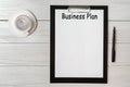 Document with title business plan and office supplies and cup of cofee Royalty Free Stock Photo