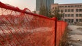 Red Plastic Mesh Fencing in Front of Unfinished Building with Construction Site Safety Barrier and Urban Development Royalty Free Stock Photo
