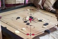 Documentary editorial image. Children playing carrom at the table. the concept of childhood and board games, brain development and