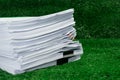 Documents pile on grass in concept save Earth and use paper econ