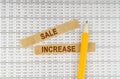 On the documents with reports are a pencil and strips of paper with the inscription - SALE INCREASE
