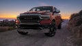 Dodge RAM 1500 driving a scenic road by the sea during a beautiful sunrise