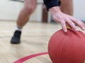 Dodgeball player picking up a red dodge ball