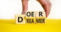 Doer or dreamer symbol. Concept words Doer or dreamer on wooden cubes. Businessman hand. Beautiful yellow table white background.