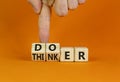 Doer or thinker symbol. Concept words Doer or thinker on wooden cubes. Businessman hand. Beautiful orange table orange background