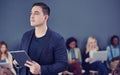 He does everything with the future in mind. a handsome young businessman using a tablet with his colleagues in the Royalty Free Stock Photo