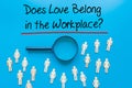 Does Love Belong in the Workplace? Sign on white paper. Man Hand Holding Paper with text. Isolated on Workers concept, Magnifying Royalty Free Stock Photo