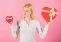 Does size really matter. Woman hold big and little heart shaped gift boxes. Which one she prefer. Girl decide which gift