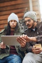 Does this thing have a camping app. a young man showing his friend something on his tablet while they spend the day